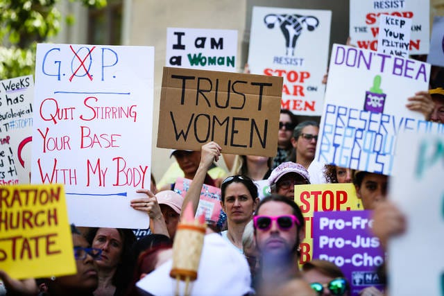 DEFIANCE — Women hold signs during a protest against recently passed abortion ban bills at the Georgia State Capitol building on May 21 in Atlanta. The ‘heartbeat’ bill would ban abortion when a fetal heartbeat is detected. (Elijah Nouvelage/Getty Images/TNS)