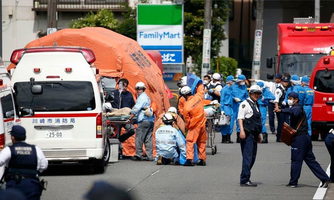 Authorities work at the scene of an attack in Kawasaki, near Tokyo on Tuesday. A man wielding a knife attacked commuters waiting at a bus stop just outside Tokyo during Tuesday morning's rush hour, Japanese authorities and media said.