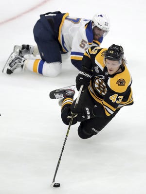 The Boston Bruins' Danton Heinen carries the puck in front of St. Louis Blues' David Perron during the first period in Game 1 of the Stanley Cup Final, Monday in Boston. [CHARLES KRUPA/THE ASSOCIATED PRESS]