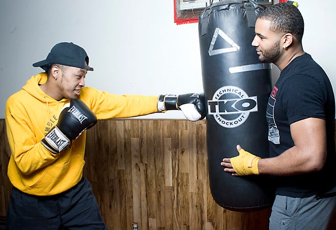 Ryizeemmion "Johnnie" Ford, left, trains on the heavy bag with stablemate, Roc Brown, at the Common Ground Athletic Club. Michael Skolosh, Special to The Review