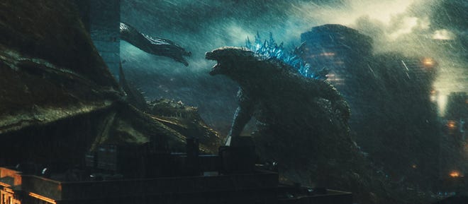 It was a dark and stormy night when Godzilla (right) went up against one of Ghidorah’s three heads. [Warner Bros.]