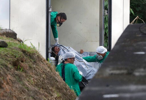 Morgue workers unload the body of an inmate, a victim of the recent prison riots, in Manaus, Brazil, Tuesday, May 28, 2019. At least 57 inmates were killed in different prisons in Amazon state in the last two days. (AP Photo/Andre Penner)