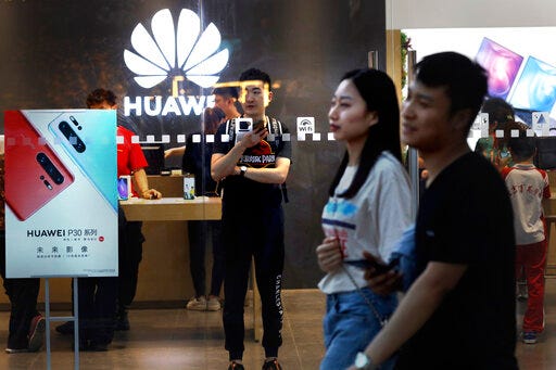 In this Monday, May 20, 2019, photo, shoppers visit a Huawei store in Beijing. Chinese tech giant Huawei has filed a motion in U.S. court challenging the constitutionality of a law that limits its sales of telecom equipment. (AP Photo/Ng Han Guan)