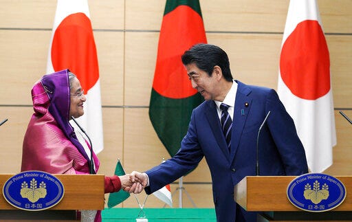 Bangladesh's Prime Minister Sheikh Hasina, left, shakes hands with Japan's Prime Minister Shinzo Abe during their joint press conference at Abe's official residence Wednesday, May 29, 2019, in Tokyo. Hasina is wooing Japan for aid, trade and investment in a visit that highlights cordial relations with the administration of Abe. (AP Photo/Eugene Hoshiko, Pool)