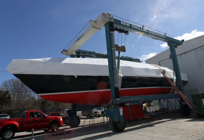 A sailboat under wraps for the winter is worked on at New England Boatworks, in this 2015 photo. [Journal files]