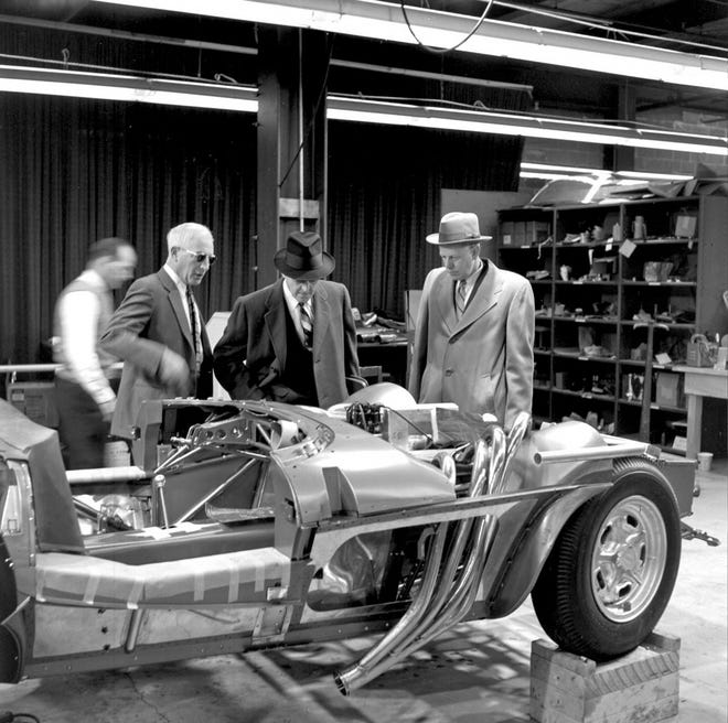 The late Zora Arkus-Duntov, left in sunglasses, shows executives the assembly of one of five 1963 Chevrolet Corvette Grand Sport race cars. Duntov had always campaigned for a mid-engine Corvette and come July 18, the 2020 mid-engine Corvette becomes a reality. Duntov passed away in 1996. [General Motors Archives]
