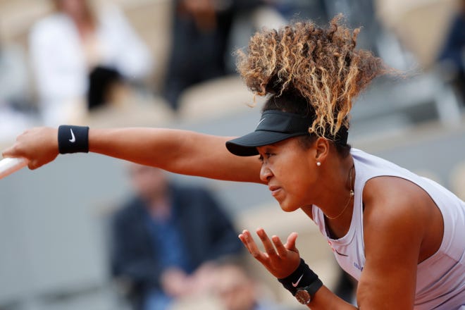 Naomi Osaka serves to Slovakia's Anna Karolina Schmiedlova during the first round of the French Open on Tuesday afternoon. [CHRISTOPHE ENA/THE ASSOCIATED PRESS]