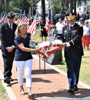 Lisa Freeman and Fort Stewart Col. Michael A. Adams laid a wreath at the flagpole in the Veterans Monument in Richmond Hill during the city's annual Memorial Day observance Monday. {Steve Scholar/For Bryan County Now]