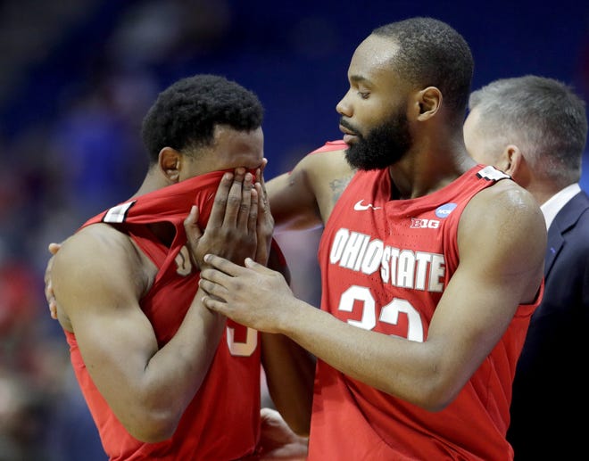 Ohio State's C.J. Jackson, left, and Keyshawn Woods comfort each other after their second round men's college basketball game against Houston in the NCAA Tournament Sunday, March 24, 2019, in Tulsa, Okla. Houston won 74-59. (AP Photo/Charlie Riedel)