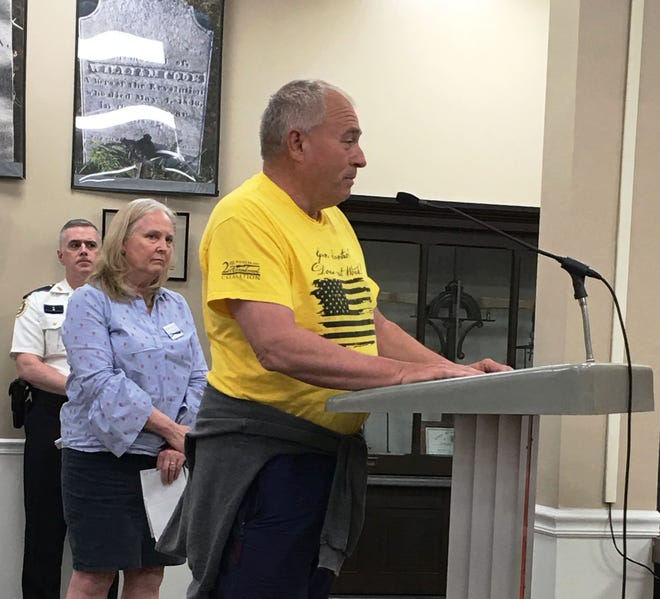 Tiverton resident Richard Rom, wearing a yellow Second Amendment sanctuary town T-shirt, speaks Tuesday night in support of a proposed resolution, while Maureen Morrow waits to speak and Police Chief Patrick Jones looks on from the back. [Marcia Pobzeznik/The Newport Daily News]