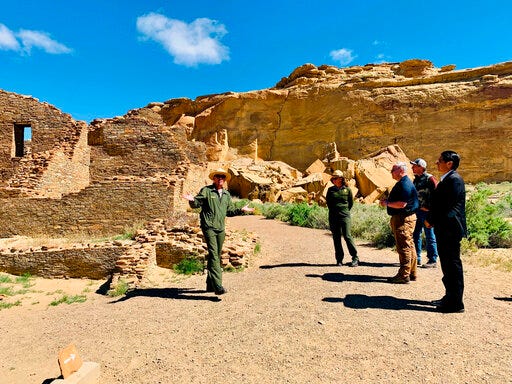 This photo provided by the Navajo Nation, Interior Secretary David Bernhardt, third from left, tours Chaco Culture National Historical Park about 95 miles northeast of Gallup, N.M., Tuesday, May 28, 2019. U.S. Sen. Martin Heinrich of New Mexico is at Bernhardt's right. Navajo Nation President Jonathan Nez is on the far right. (Jared Touchin/Navajo Nation via AP)