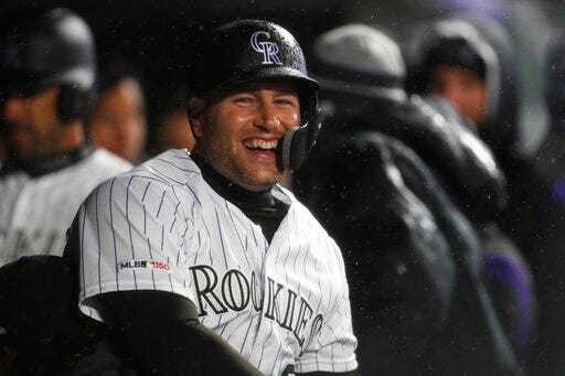 Colorado Rockies' Chris Iannetta celebrates with teammates as he returns to the dugout after hitting a two-run home run off Arizona Diamondbacks starting pitcher Merrill Kelly in the seventh inning of a baseball game, Tuesday, May 28, 2019, in Denver. Colorado won 6-2. (AP Photo/David Zalubowski)