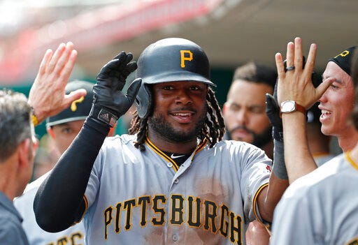 Pittsburgh Pirates' Josh Bell (55) celebrates a three-run home run off Cincinnati Reds relief pitcher Michael Lorenzen in the dugout during the seventh inning of a baseball game, Wednesday, May 29, 2019, in Cincinnati. (AP Photo/Gary Landers)