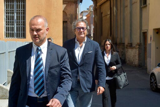 Dr. Guido Fanelli, center, arrives with his lawyer Salvatore Coniglio, left, and an unidentified assistant at Parma's law court in northern Italy to answer magistrates' questions on Saturday, May 13, 2017. Fanelli allegedly took kickbacks from pharmaceutical executives to help push opioids in Italy. Police huddled for hours each day, headphones on, eavesdropping on the doctor. (AP Photo/Marco Vasini)