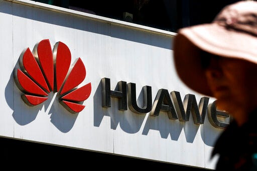 A woman walks by a Huawei retail store in Beijing, Wednesday, May 29, 2019. Chinese tech giant Huawei filed a motion in U.S. court Wednesday challenging the constitutionality of a law that limits its sales of telecom equipment, the latest action in an ongoing clash with the U.S. government. (AP Photo/Andy Wong)