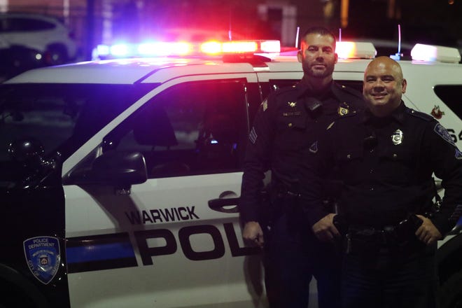Officer Mark Jandreau, right, and Sgt. Jed Pineau get ready to head out on a Friday night last November with a camera crew from the A&E series “Live PD.” [The Providence Journal, file / Bob Breidenbach]