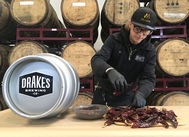 Hal McConnellogue, cellar manager at Drake's Brewing Company in San Leandro, Calif., works with chipotle peppers to infuse beer with a unique flavor. [AP photo / Haven Daley]