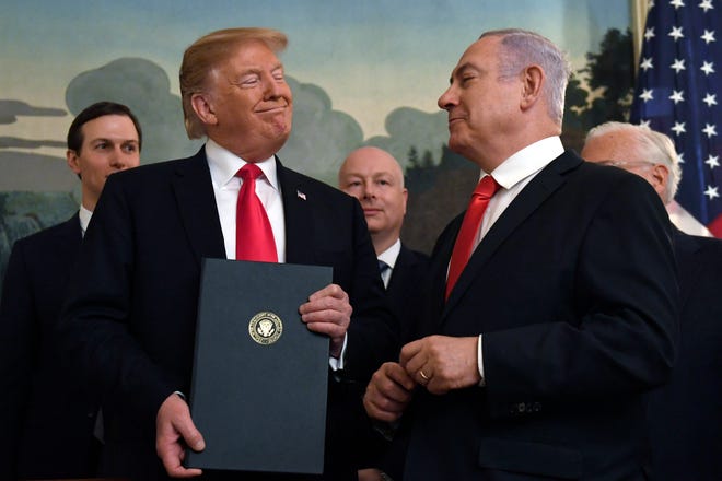 FILE - In this March 25, 2019 file photo, President Donald Trump smiles at Israeli Prime Minister Benjamin Netanyahu, right, after signing a proclamation at the White House in Washington. Netanyahu has been a vocal critic of Iran over the years, accusing the Islamic Republic of sinister intentions at every opportunity. But the outspoken Israel leader has remained uncharacteristically quiet throughout the current crisis between the U.S. and Iran, not wanting to be seen as pushing the Americans into a military confrontation and wary of being drawn into fighting with Iran’s powerful proxy, the Lebanese militant group Hezbollah. (AP Photo/Susan Walsh, File)