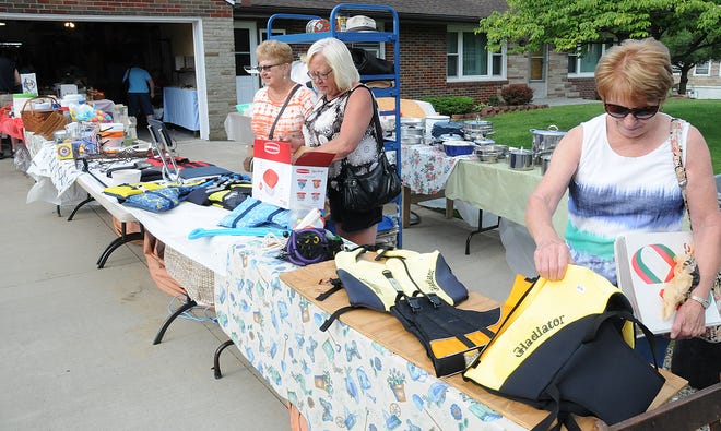 Sisters-in-law Cathy Ogle, Janet Kress and Donna Kress, from left, shop a sale near Old Washington during the National Road Yard Sale days Wednesday morning.