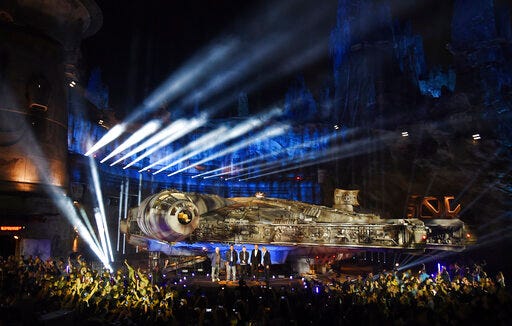The Millennium Falcon starship is pictured onstage during a dedication ceremony for the new Star Wars: Galaxy's Edge attraction at Disneyland Park, Wednesday, May 29, 2019, in Anaheim, Calif. From left, "Star Wars" film franchise creator George Lucas, cast members Billy Dee Williams and Mark Hamill, Walt Disney Co. Chairman and CEO Bob Iger and cast member Harrison Ford stand onstage. (Photo by Chris Pizzello/Invision/AP)