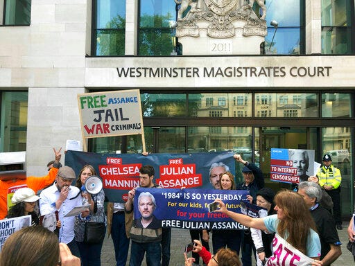Julian Assange supporters gather outside Westminster Magistrates Court in London, Thursday May 30, 2019. Assange has missed a court session apparently due to health problems. Assange had been expected to appear from prison via video link at a brief extradition hearing Thursday at Westminster Magistrates’ Court. (Thomas Hornall/PA via AP)