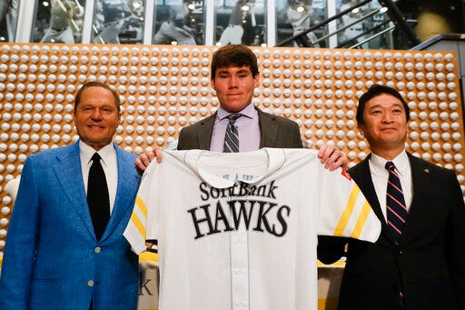 Sports agent Scott Boras, left, SoftBank Hawks pitcher Carter Stewart Jr., center, and Hawks General Manager, Sugihiko Mikasa pose during a baseball news conference in Newport Beach, Calif., Thursday, May 30, 2019. After failing to sign with Atlanta and losing a grievance against the Braves, 19-year-old right-hander Carter Stewart has agreed to a six-year contract with the Fukuoka SoftBank Hawks of Japan's Pacific League (AP Photo/Chris Carlson)
