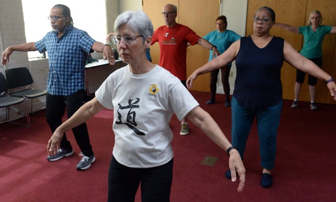 Kim Ragland, tai chi instructor, leads a Level I class at the Mebane Public Library on Wednesday, May 29. [Robert Thomason / Times-News]