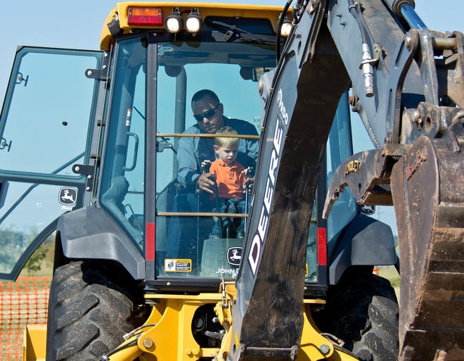 At a Touch a Truck event in Round Rock in 2014, Weston Wilhelm touches the controls of the backhoe with help from Round Rock employee Albert de la Torre.

[HENRY HUEY FOR ROUND ROCK LEADER]