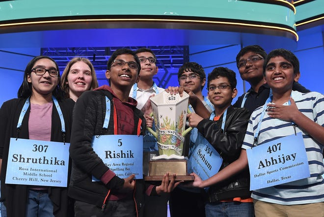 Co-champions of the 2019 Scripps National Spelling Bee, from left, Shruthika Padhy, 13, of Cherry Hill, N.J., Erin Howard, 14, of Huntsville, Ala., Rishik Gandhasri, 13, of San Jose, Calif., Christopher Serrao, 13, of Whitehouse Station, N.J., Saketh Sundar, 13, of Clarksville, Md., Sohum Sukhatankar, 13, of Dallas, Texas, Rohan Raja, 13, of Irving, Texas, and Abhijay Kodali, 12, of Flower Mound, Texas, hold the trophy in Oxon Hill, Md., Friday. [SUSAN WALSH/ASSOCIATED PRESS]
