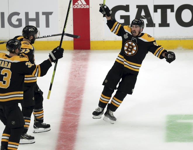 Brad Marchand, right, celebrates his empty-net goal during the third period in Game 1 of the Stanley Cup Final against the St. Louis Blues on Monday. (AP File Photo/Charles Krupa)