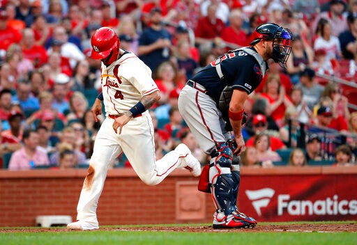 St. Louis Cardinals' Yadier Molina (4) scores past Atlanta Braves catcher Tyler Flowers during the fifth inning of a baseball game Saturday, May 25, 2019, in St. Louis. (AP Photo/Jeff Roberson)
