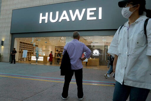 In this photo taken Monday, May 20, 2019, a man stands outside a Huawei store in Beijing. The Financial Times reported Friday, May 31, 2019 that tech giant Huawei has ordered its employees to cancel technical meetings with American contacts and has sent home numerous U.S. employees working at its Chinese headquarters. (AP Photo/Ng Han Guan)