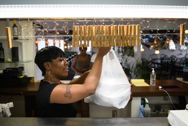 Marquila Ray picks up an order for a customer at Jazzio's Soul Food Cuisine at 2918 Bragg Blvd. [Andrew Craft/The Fayetteville Observer]