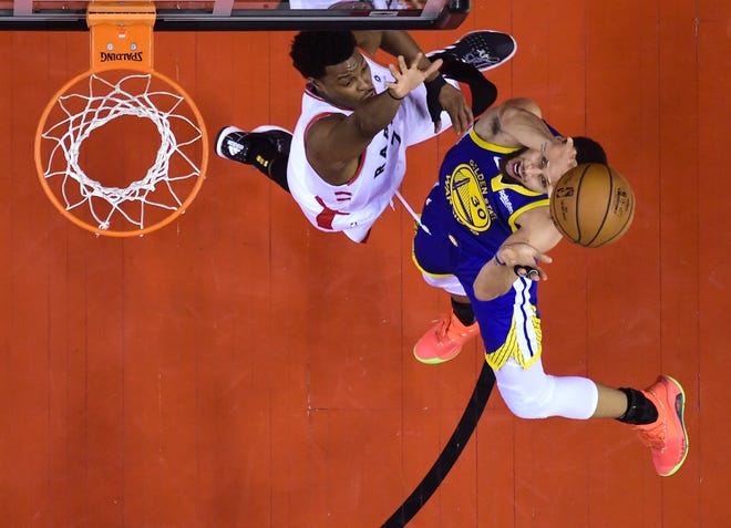 Golden State Warriors guard Stephen Curry (30) shoots past Raptors guard Kyle Lowry during Game 1 of the NBA Finals on Thursday in Toronto. Game 2 is Sunday. [NATHAN DENETTE/THE CANADIAN PRESS VIA AP]
