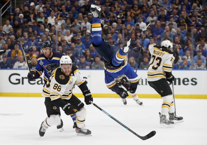 St. Louis Blues center Brayden Schenn, second from right, flips past Boston Bruins right wing David Pastrnak (88) during the first period of Game 3 of the Stanley Cup Final on Saturday in St. Louis. [AP Photo/Jeff Roberson]