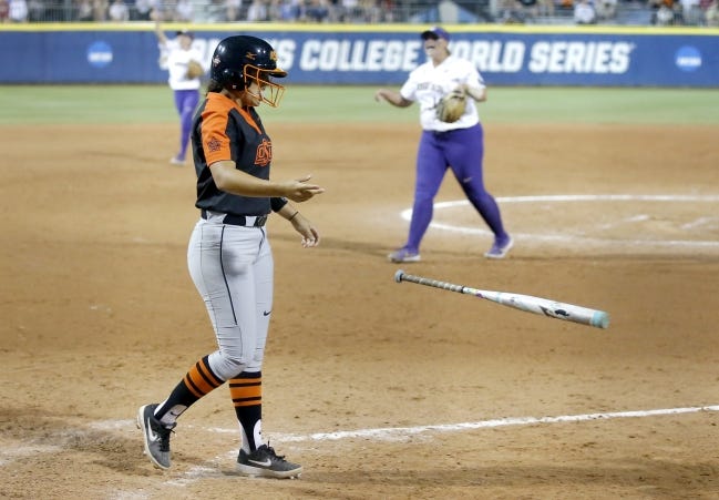 Oklahoma State's Chyenne Factor tosses her bat after striking out for the last out of Washington's 1-0 win Saturday in an elimination game of the Women's College World Series at USA Softball Hall of Fame Stadium. [Sarah Phipps/The Oklahoman]
