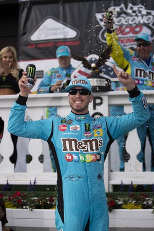 Kyle Busch celebrates in victory lane after winning a NASCAR Cup Series auto race at Pocono Raceway, Sunday in Long Pond, Pa. [MATT SLOCUM/THE ASSOCIATED PRESS]