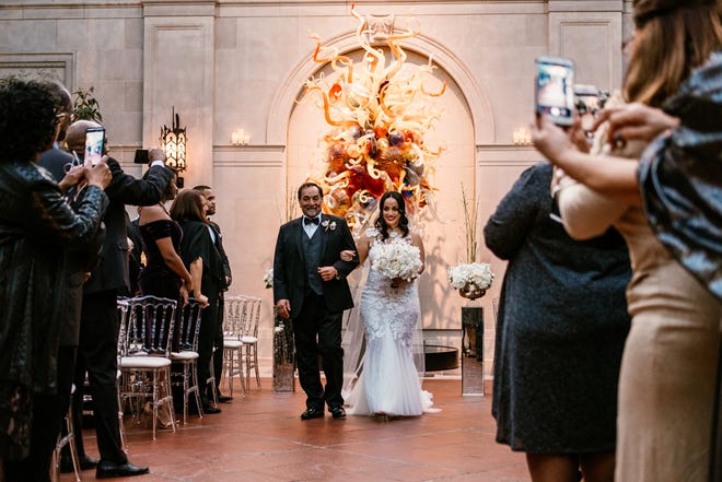 Guests aim for the perfect angle of Ariana Harris coming down the aisle.