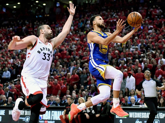 Golden State Warriors guard Stephen Curry (30) drives to the net as Toronto Raptors center Marc Gasol (33) looks on during the first half of Sunday's Game 2 of the NBA Finals. [FRANK GUNN/THE CANADIAN PRESS VIA ASSOCIATED PRESS]