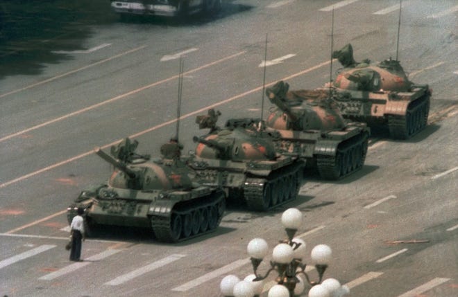 A Chinese man stands alone to block a line of tanks in Tiananmen Square on June 5, 1989. The man, calling for an end to violence and bloodshed against pro-democracy demonstrators, was pulled away by bystanders, and the tanks continued on their way. The Chinese government crushed a student-led demonstration for democratic reform and against government corruption, killing hundreds or perhaps thousands of demonstrators. [AP Photo/Jeff Widener/File]