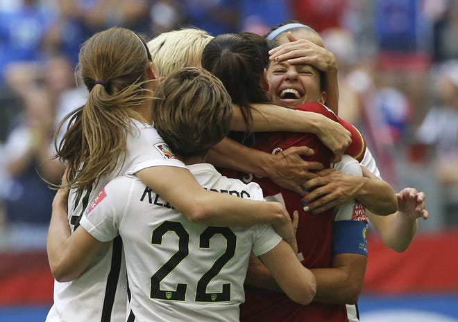 United States' Carli Lloyd, right, celebrates with teammates after Lloyd scored her third goal against Japan during the FIFA Women's World Cup soccer championship on July 5, 2015, in Vancouver, Canada. [AP Photo/Elaine Thompson, File]