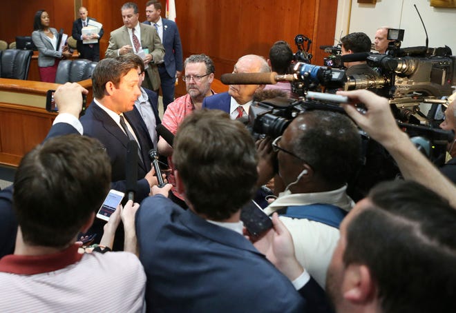 Gov. Ron DeSantis, left, answers questions from the media after the Florida Cabinet meeting Tuesday in Tallahassee. [Steve Cannon/The Associated Press]
