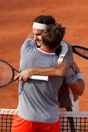 Roger Federer and Stan Wawrinka hug after their quarterfinal match of the French Open which Federer won in four sets, 7-6 (7-4), 4-6, 7-6 (7-5), 6-4, at the Roland Garros stadium Tuesday in Paris. [Jean-Francois Badias/The Associated Press]