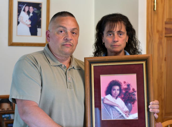 Peter Vasquez and his wife, Margarita Vasquez, of Auburn hold a portrait of Peter's sister, 17-year-old Nereida Melendez, who was killed 30 years ago. [T&G Staff/Christine Peterson]