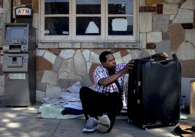 Charles Lewis packs up his belongings before heading to look for a new place to sleep downtown in Austin. [NICK WAGNER/AMERICAN-STATESMAN]