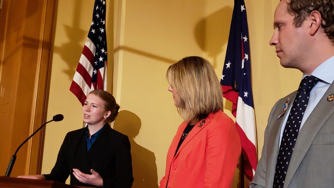 Ellie Warren (left), a junior at Hilliard Davidson High School, speaks to reporters about her support of a bill that would require insurance coverage for hearing aids. Bill sponsors Reps. Allison Russo, R-Upper Arlington, and Casey Weinstein, R-Hudson, look on. [Jim Siegel/Dispatch]
