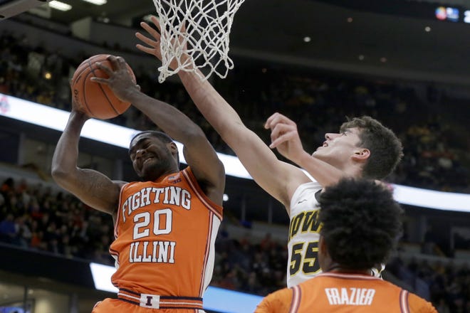 Illinois's Da'Monte Williams (20) grabs a rebound against Iowa's Luka Garza (55) during the first half of an NCAA college basketball game in the second round of the Big Ten Conference tournament, Thursday, March 14, 2019, in Chicago. (AP Photo/Kiichiro Sato)