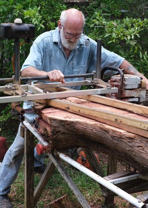 Woodcrafter Jim Rivers carves up a cedar log as part of his artistic process. He creates furniture and other funcitonal pieces, as well as more decorative pieces. [CONTRIBUTED]
