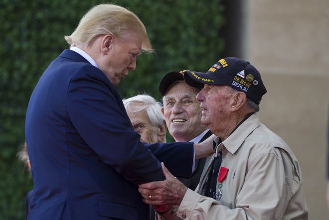 President Donald Trump speaks with veterans during a ceremony to commemorate the 75th anniversary of D-Day at the American Normandy cemetery Thursday in Colleville-sur-Mer, Normandy, France. [The Associated Press]