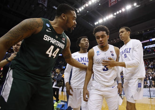 Duke guard Tre Jones (3) is consoled by Michigan State forward Nick Ward (44) after losing to Michigan State at the end of an NCAA men's East Regional final college basketball game in Washington, Sunday, March 31, 2019. (AP Photo/Alex Brandon)